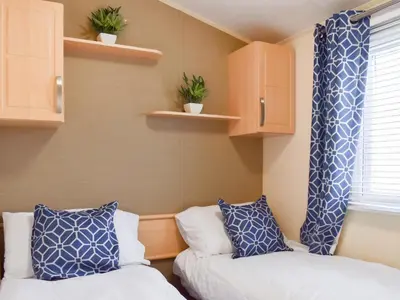 a room with two beds and a window and shelves at Stay And Sea in Heysham