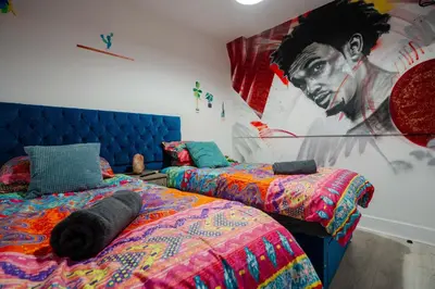 a bedroom with two beds and a large painting on the wall at LFC theme - free parking - 2 bathroom in Liverpool