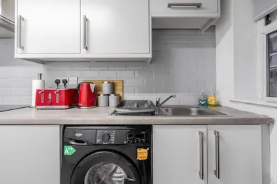 a kitchen with a washing machine and a sink at LFC theme - free parking - 2 bathroom in Liverpool