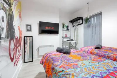 a bedroom with a bed with a colorful comforter at LFC theme - free parking - 2 bathroom in Liverpool