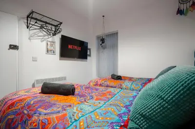 a bed with a colorful comforter in a room at LFC theme - free parking - 2 bathroom in Liverpool