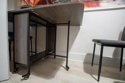 a wooden table with two chairs next to a wall at LFC theme - free parking - 2 bathroom in Liverpool