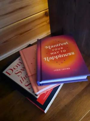 three books stacked on top of each other on a table at The Laurels - Wood Fired Hot Tub and Firepit in Poulton le Fylde