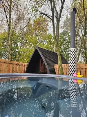 a dog house sitting next to a swimming pool at The Laurels - Wood Fired Hot Tub and Firepit in Poulton le Fylde
