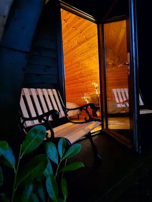 a wooden bench sitting on the porch of a cabin at The Laurels - Wood Fired Hot Tub and Firepit in Poulton le Fylde
