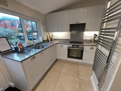 a kitchen with white cabinets and a sink at Sunny Bank, Cark-in-Cartmel in Cark
