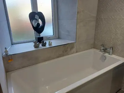 a white bath tub in a bathroom with a window at Sunny Bank, Cark-in-Cartmel in Cark