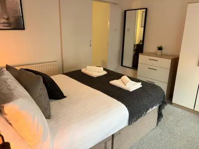 a bedroom with a large bed with two towels on it at Jude's Place 01 in Liverpool