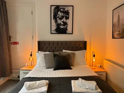 a bedroom with a large bed and two lamps at Jude's Place 01 in Liverpool