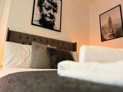 a bedroom with a bed with two pictures on the wall at Jude's Place 01 in Liverpool