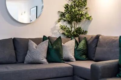 a couch with four pillows on it with a mirror at Jude's Place 01 in Liverpool