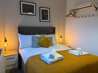 a bedroom with a bed with towels on it at Jude's Place One Bedroom Apartments in Liverpool
