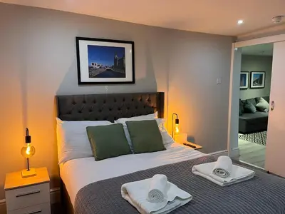 a bedroom with a large bed with towels on it at Jude's Place One Bedroom Apartments in Liverpool