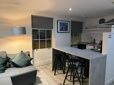 a kitchen and living room with a couch and a counter at Jude's Place One Bedroom Apartments in Liverpool