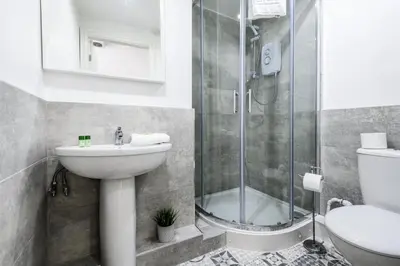 a bathroom with a shower and a sink and a toilet at Jude's Place One Bedroom Apartments in Liverpool