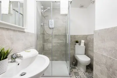 a bathroom with a shower and a toilet and a sink at Jude's Place in Liverpool