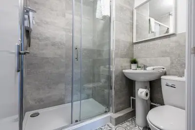 a bathroom with a shower and a toilet and a sink at Jude's Place in Liverpool