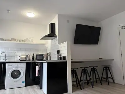 a kitchen with a washer and dryer in it at Jude's Place in Liverpool
