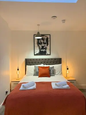 a bedroom with a large bed with two towels on it at Jude's Place in Liverpool