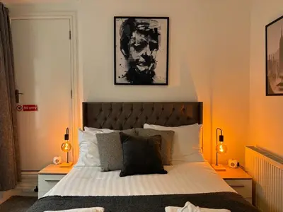 a bedroom with a large bed with two night stands at Jude's Place in Liverpool