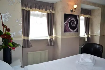 a bedroom with a bed and a window at Lyndene Hotel in Blackpool