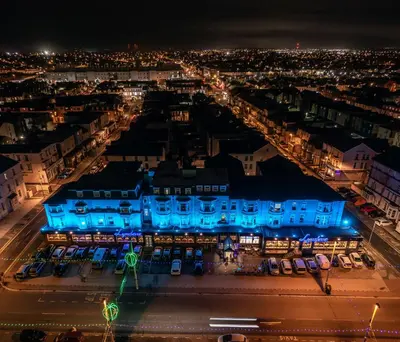 a city at night with a blue building at Lyndene Hotel in Blackpool