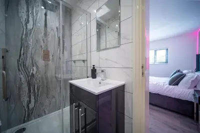 a bathroom with a sink and a shower and a bed at 20 Guest Luxury Stay - Private Pool, Hot Tub & Gym in Lytham St Annes