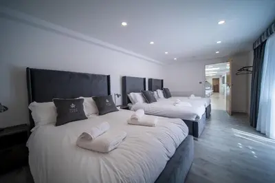 a row of four beds in a room at 20 Guest Luxury Stay - Private Pool, Hot Tub & Gym in Lytham St Annes