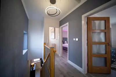a hallway with a stairway leading to a bedroom at 20 Guest Luxury Stay - Private Pool, Hot Tub & Gym in Lytham St Annes