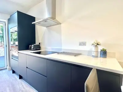 a kitchen with blue cabinets and a sink at Mode Cottage in Lytham St Annes