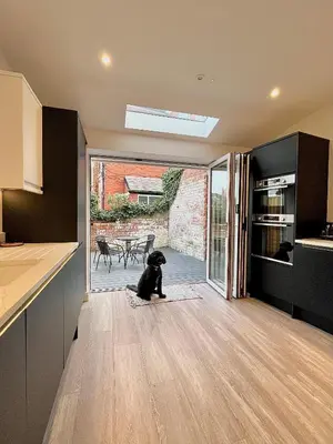 a dog sitting on a rug in a kitchen at Mode Cottage in Lytham St Annes