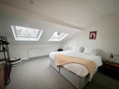 a bedroom with a bed with two skylights at Mode Cottage in Lytham St Annes