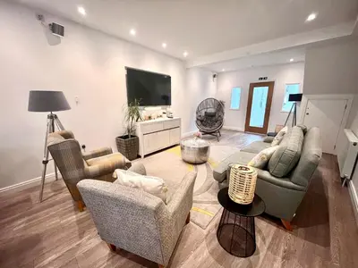 a living room with furniture and a flat screen tv at Mode Cottage in Lytham St Annes