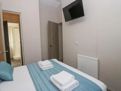 a bedroom with a bed with towels on it at The Three Bears Lodge, Coniston Drive 11 in Carnforth