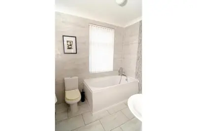 a white bathroom with a tub and a toilet at Anfield Haven for 6 in Liverpool