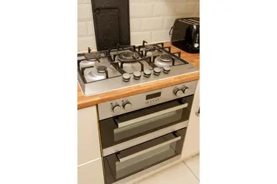 a stove top oven in a kitchen next to a counter at Anfield Haven for 6 in Liverpool