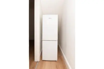 a white refrigerator in the corner of a room at Anfield Haven for 6 in Liverpool