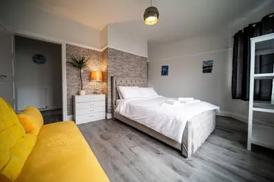 a bedroom with a white bed and a brick wall at Spacious Apartment With A Terrace Style Rooftop in Cleveleys
