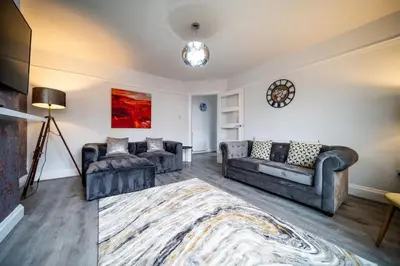 a living room with two couches and a rug at Spacious Apartment With A Terrace Style Rooftop in Cleveleys
