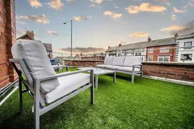 two chairs sitting on the roof of a building at Spacious Apartment With A Terrace Style Rooftop in Cleveleys