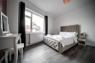 a bedroom with a bed and a desk and a window at Spacious Apartment With A Terrace Style Rooftop in Cleveleys