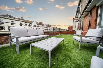 a couch and two chairs sitting on a lawn at Spacious Apartment With A Terrace Style Rooftop in Cleveleys