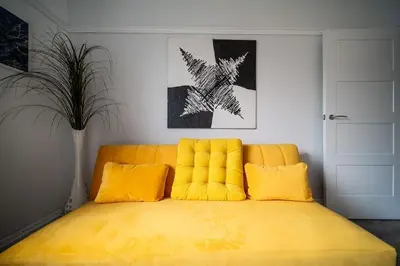 a yellow bed with yellow pillows in a room at Spacious Apartment With A Terrace Style Rooftop in Cleveleys