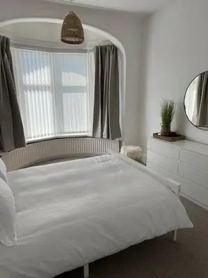 a bedroom with a white bed and a window at Parking Walk to Tower Winter Gardens and Main Attractions in Blackpool