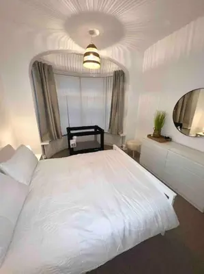 a bedroom with a large white bed and a mirror at Parking Walk to Tower Winter Gardens and Main Attractions in Blackpool
