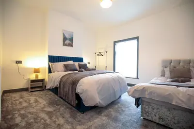 a bedroom with two beds and a window at Dixon House, Sleeps 6, Free Parking, Long or Short Stays - by NMB Property in Horwich