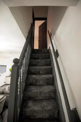 a stairway leading up to a brown door at Dixon House, Sleeps 6, Free Parking, Long or Short Stays - by NMB Property in Horwich