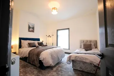 a bedroom with two beds and a window at Dixon House, Sleeps 6, Free Parking, Long or Short Stays - by NMB Property in Horwich