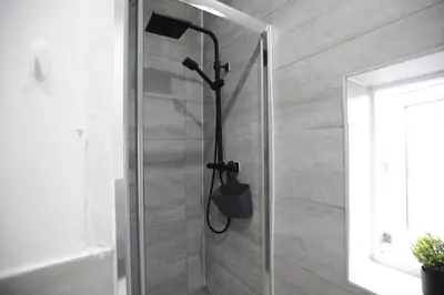 a shower with a black shower head in a bathroom at Dixon House, Sleeps 6, Free Parking, Long or Short Stays - by NMB Property in Horwich