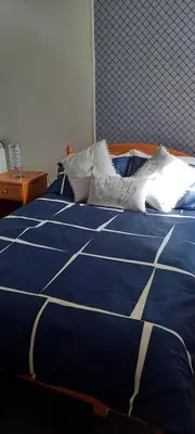 a blue bed with white pillows on top of it at Shananagens Guesthouse in Blackpool